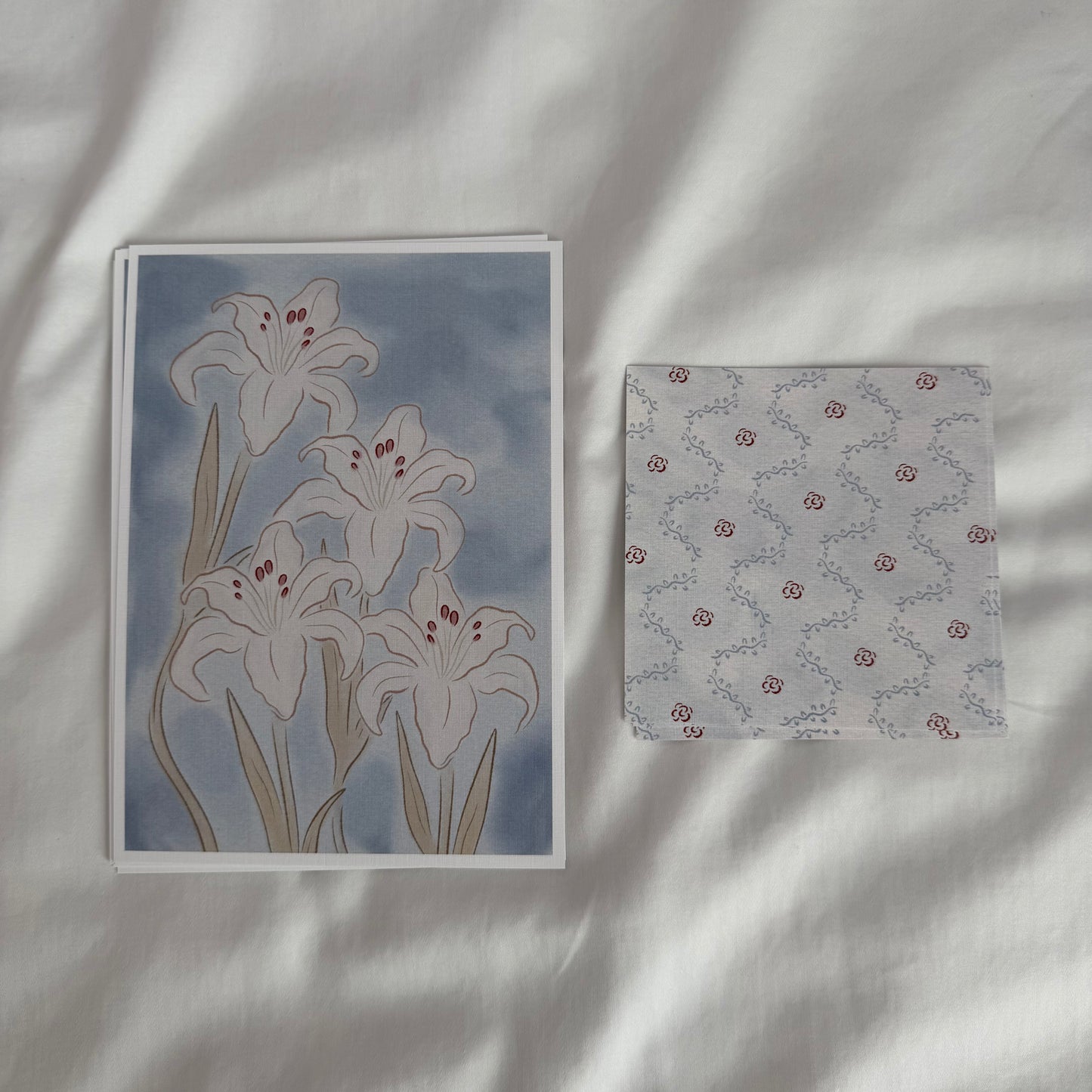 A 5x7 white lily art print paired with a matching 4x4 dainty patterned print in soft blue tones.