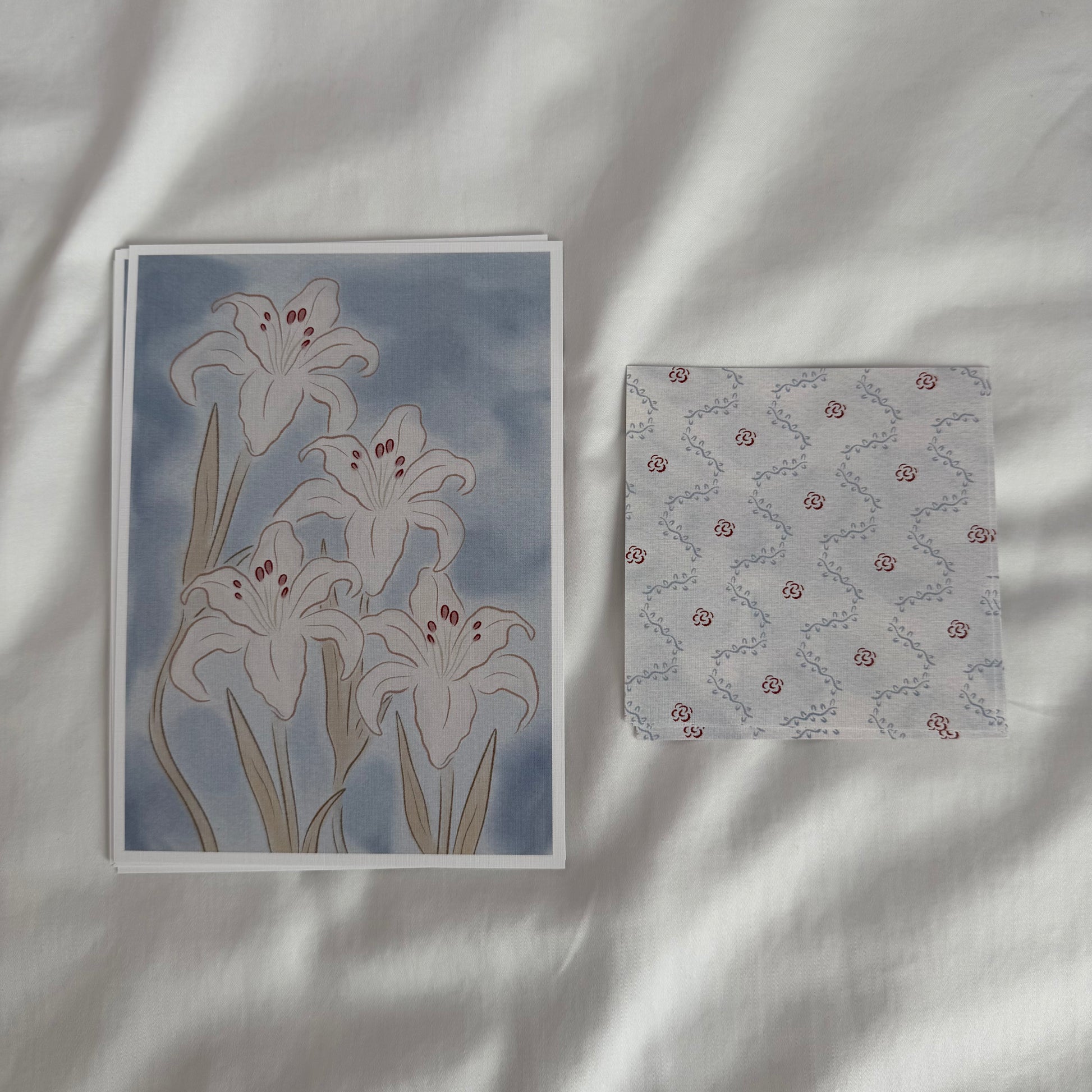A 5x7 white lily art print paired with a matching 4x4 dainty patterned print in soft blue tones.