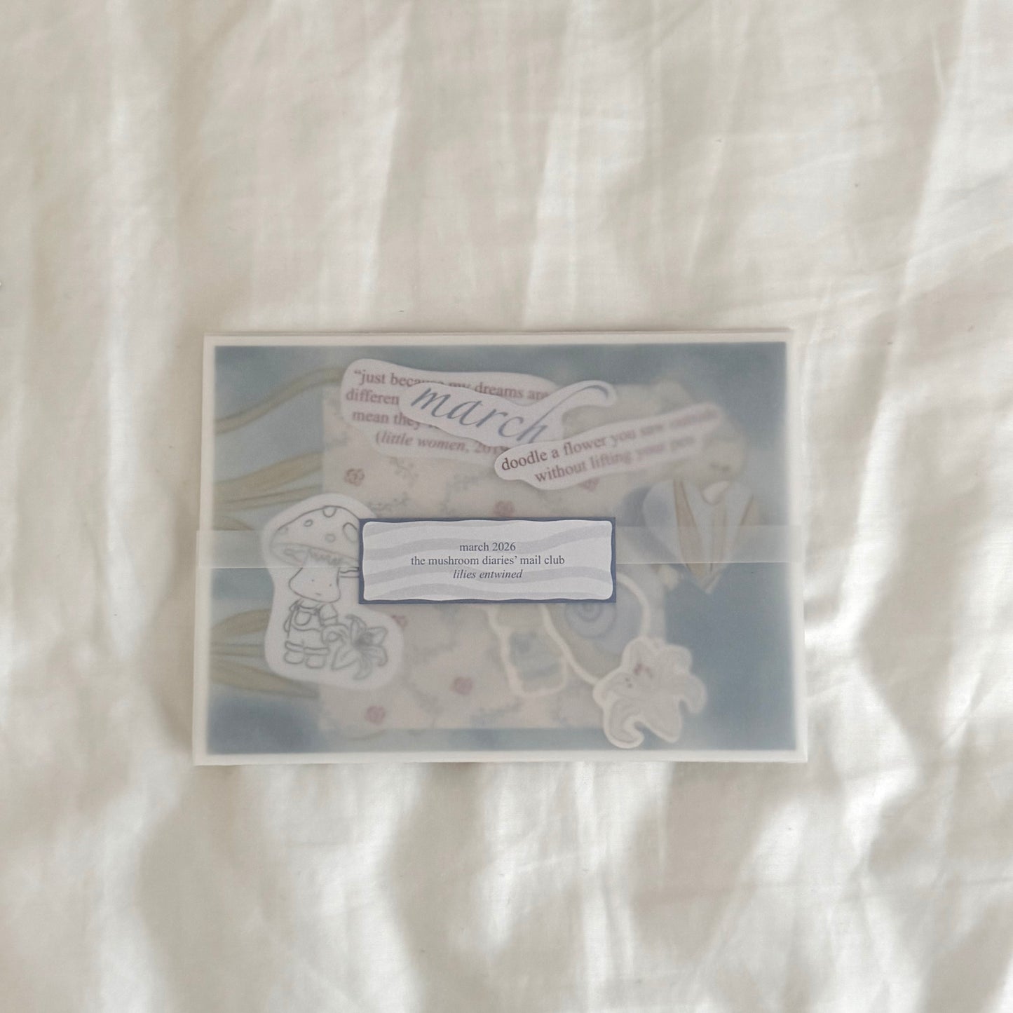 Envelope containing a 5x7 white lily art print, a 4x4 matching dainty patterned art print in soft blues, three matte vinyl stickers, journal prompts, an activity prompt, a mini coloring card of a mushroom character (marker bleed-safe), mini cards for journaling, and three mini cut-out lined paper hearts.