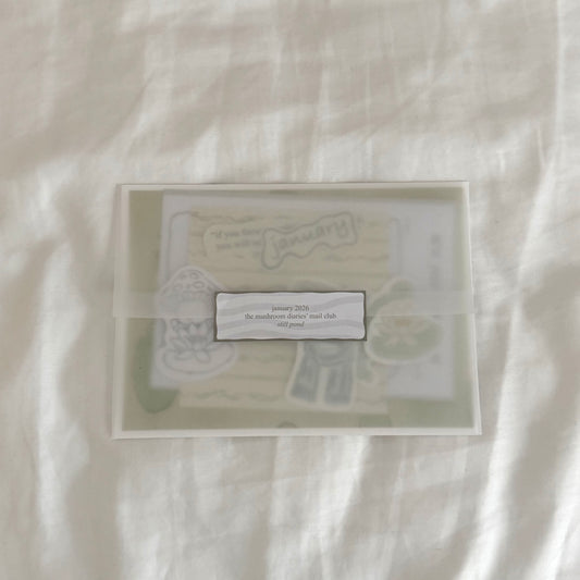 Envelope containing a 5x7 water lily art print, a 4x4 matching dainty patterned art print in soft sage green tones, five matte vinyl stickers, journal prompts, an activity card, a mini coloring card of a mushroom character (marker bleed-safe).