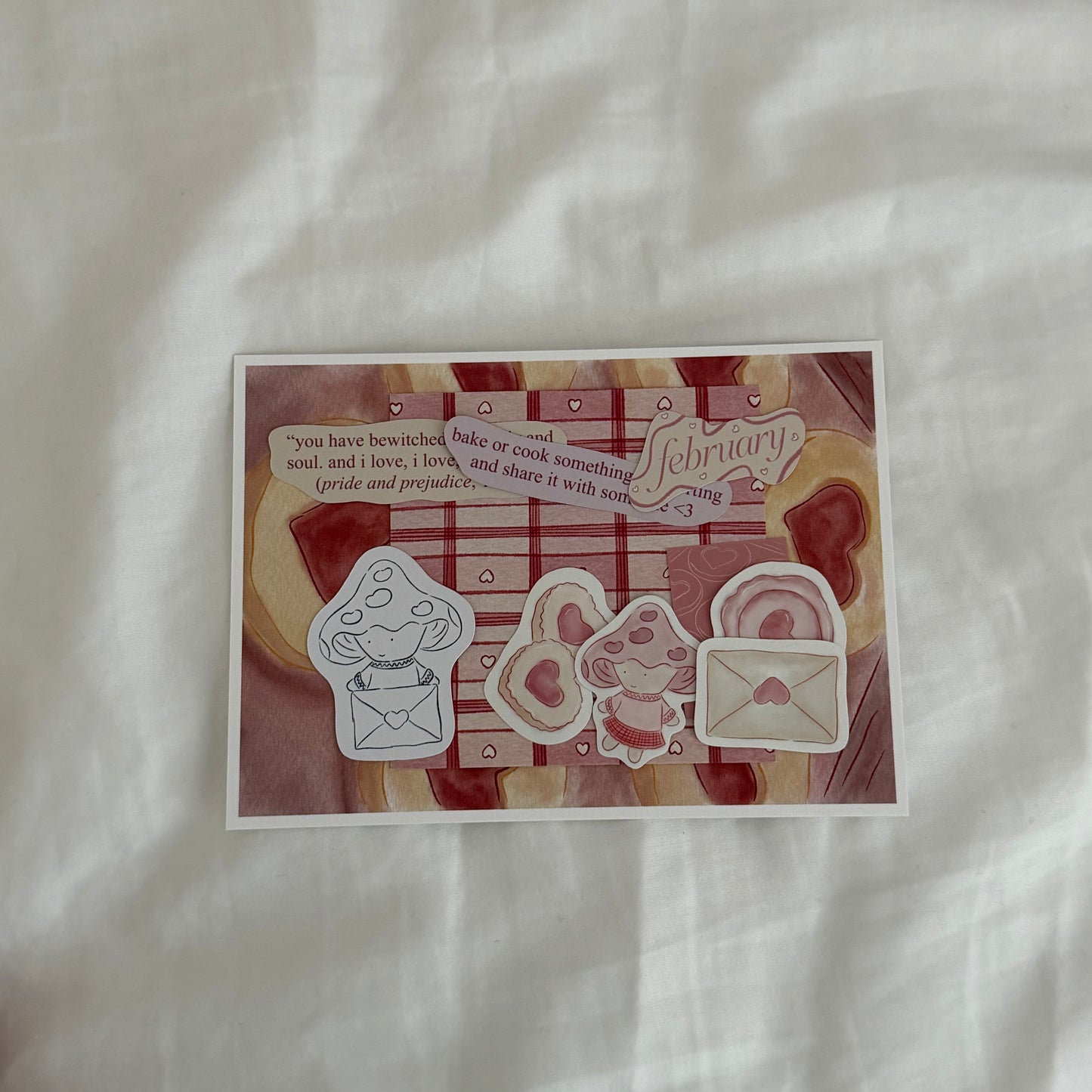Inside an open envelope: 5x7 cookie print, 4x4 matching patterned print in red tones, five matte stickers, beige and pink journal and activity prompts, a mini mushroom coloring card, mini journaling cards, and three small lined paper hearts.