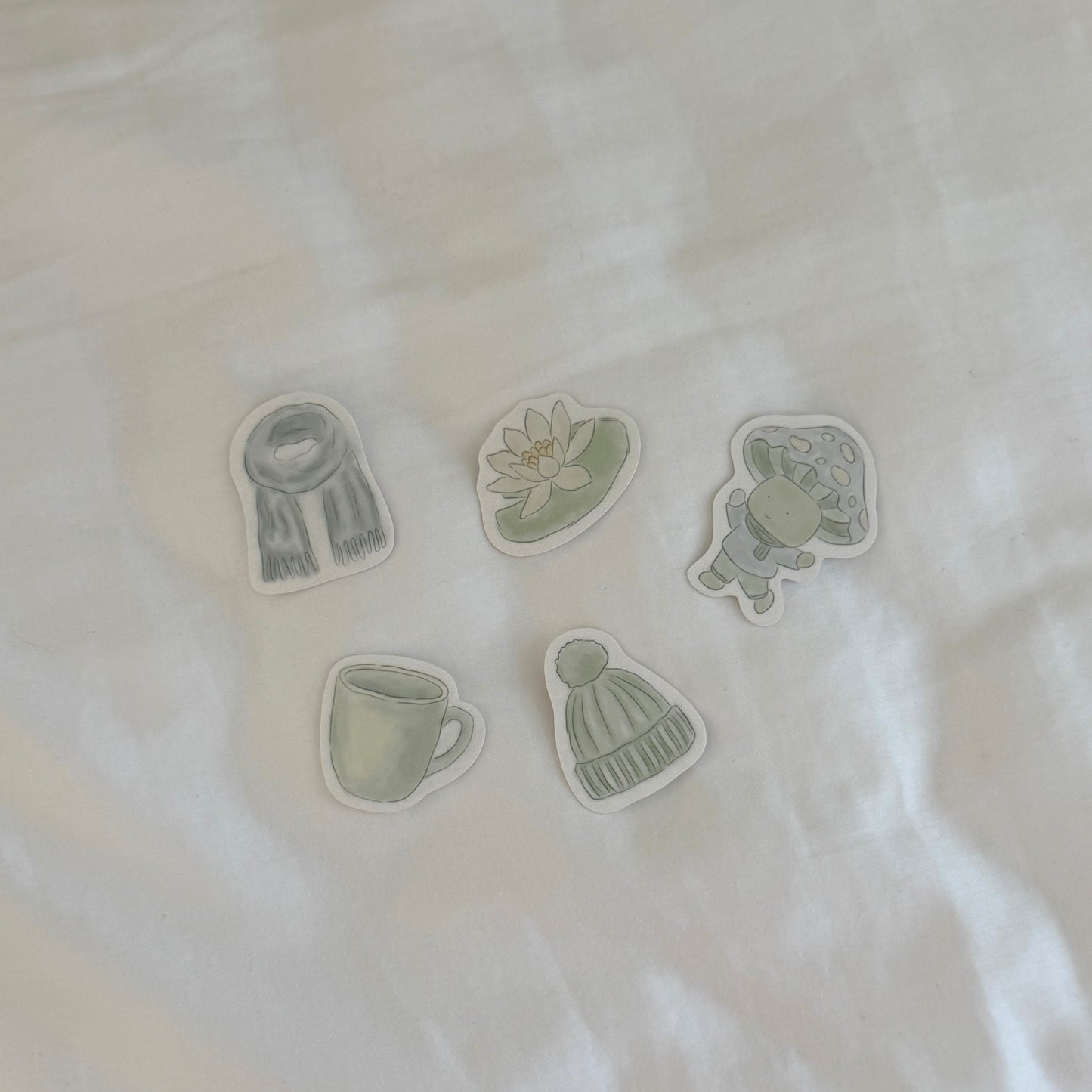 Set of five green and gray illustrations on a white fabric background